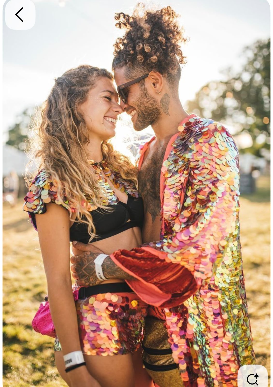 Pareja en un festival con looks a juego de lentejuelas grandes arcoíris